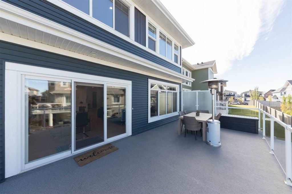A 2-story blue home showing a large rear deck with waterproof vinyl flooring.